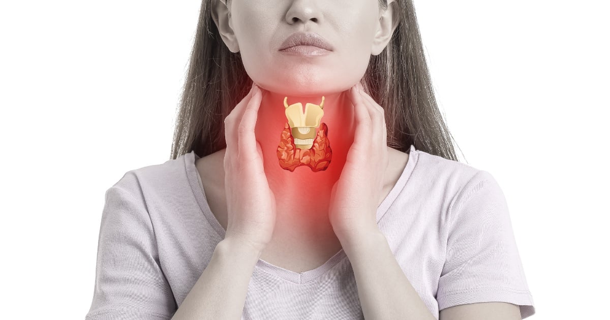 Woman holding her throat and showing  where her thyroid is 